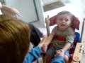 lewis in his giraffe chair, with jenna helping him to clap hands.