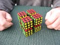 Buy at www.shapeways.com Copyright (c) 2012, M. Oskar van Deventer. Cube Twister are eight Rubik's Cubes connected by rods. However, as the eight corners of each cube are solidly connected, each row or column of cubes tumbles are a whole. The motion of this puzzle was first suggested by Nouri Khalifa around 2009. Nouri's prototype was based on eight cubes with holes, and a stick to turn pairs of cubes. In 2010, Sigurd suggested a similar type of motion in a post at the Twisty Puzzles Forum. It was Mike Armbrust who first proposed a proper Rubik's style mechanism for this concept. Thispuzzle was 3D-printed using nylon-powder SLS technology, which explains its price. It is the very first prototype, costing its designer and maker a lot of money to create. Please do not confuse it for a cheap mass-produced puzzle.
