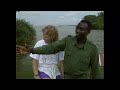 march 1996
debby cox has a dream. she wants to free a group of prisoners. incarcerated at entebbe zoo, uganda, there is a colony of orphan chimps. they charge around their wire-mesh cage, desperate for affection. their big hairy arms will embrace just about anything, including the camera! six hours drive away, an island sanctuary in queen elizabeth national park allows captive chimps to lead a semi-wild existence. an experiment to introduce a 3 month year old orphan into the group proves successful. debby and her zoo director hope to establish a similar sanctuary at entebbe. in the kigali reserve, harvard university professor, richard wrangham has spent twelve years crouching in the undergrowth, watching wild chimps in their natural environment. we hide in a clearing as two young males eat cautiously in front of the camera. but the chimp population is under threat from in-breeding. debby wants to solve the problem by gradually introducing her orphan chimps into the gene pool. significantly, 98% of those chimp genes are exactly the same as our own. if it is a crime to imprison innocent humans, surely the same applies to debby's 'chimp people'.