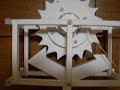 It is the clock escapement made from paper. The length of a pendulum is 25cm. A cycle is about 1 second.