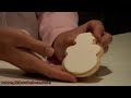 Instructional video on how to create a frosty the snowman cookie with fondant and sugarpaste decorations.