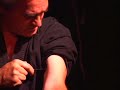 Torture King piercing through bicep