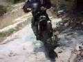 Dirt bike riding up a dry crick bed