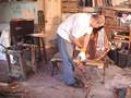 sculptor sculpting a human-sized copper frog