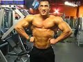 Huge bodybuilder posing in the gym after workout