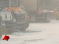 Highway crews across the Midwest labored Wednesday to carve through snowdrifts that a blizzard piled up 10 feet high as hundreds of stalled motorists waited in bitter cold. The storm was linked to at least four deaths. (March 11)