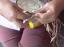 Chela adds a different colored group of chambira to her basket.