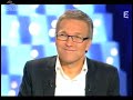 baptiste appears on a french tv show and promptly wears a construction worker's vest but not before taking off his perfectly pressed shirt.