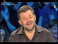 baptiste appears on a french tv show and promptly wears a construction worker's vest but not before taking off his perfectly pressed shirt.
