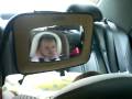 Talking to herself in a safety mirror, baby car ride