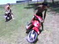 Julito haciendo ceritos en el pasto con una moto Yumbo c110