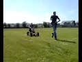 two boys messing with some young boys go-cart.