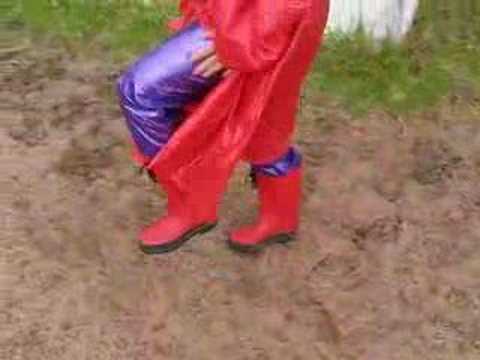 Rainweargirl - Second part of me walking in red PVC coat, camisole, rainhat, boots and purple PVC jeans.