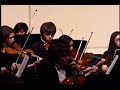 the broken arrow high school orchestra plays a classic song for contest and endures an overheated light show, causing the stage to go black numerous times. notice how the music continues without flaw, even as the lights become a major disctraction.