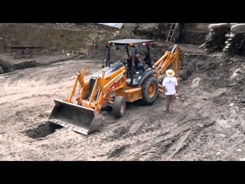 retro excavadora - La Retroexcavadora cavando zanca en terreno profundo para colocacion de tuberia. Retro excavadora CASE con brazo hidraulico cavando en terreno duro la excava...