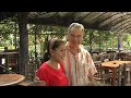 Roky führt nach dem Essen Thailandische Kühe übern Fluß