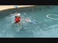 videos de Child learning to float with clothes on