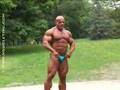 big bodybuilder posing in park