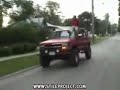 Un loco se pone de pie en la puerta de un coche en marcha