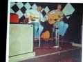 during the summer of 1977, after busking around europe i came home for something to eat and immediately ended up going on a two week tour of cornwall and the scilly isles with cappo - still needing something to eat.
sorry about the still photo, but its all i have, the song and the man is the special bit.  can anybody help me identify the pub?  i thought it was in perranporth, the 'green parrot' ???  it was run by a big blonde woman in a big black frock who frightened me shitless.  i asked her for  a gig and she said ' give me one good reason', -i couldn't get any words out. answers on a postcard please ! notice the 4x10's pa system!
we ended up in newquay at the lovely lovely dennis quixbys' place, who never put his teeth in and had a never ending bottle of brandy. god i was so sick! does anybody out there remember these people??
tony made 'punch and judy man' his own song with all respect to john connoly.  tony tortured me with his own brand of english folk song, and his unique interpretation of it, songs which have stuck in my brain all these years.
in the photo he is playing a 'tama' acoustic, god knows why he played this instead of his beloved martin d28.  i had my old gibson j45, and we would play 'goodnight irene' together and then strip off! what a show!
he always ingratiated himself with audiences and i remember a lovely crowd of german visitors being treated to storys of spitfires and lancasters. went down a bomb.
i have some other snippets of 'cappo' which i will soon put on but would love to hear from anyone else out there.  if theres anyone playing the banjo in heaven tonite , its cappo!