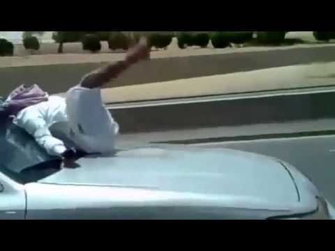 Un arabo fuori di testa invia SMS seduto sul cofano di un’automobile Un arabo fuori di testa invia SMS seduto sul cofano di un’automobile