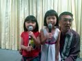 2 kids sing together with their grandfather during a dinner celebration on 19th july 2008.