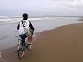前日の風がおさまらず、２日目の朝ライダーズミーティングに向かう途中の映像です。家族は朝食のビュッフェを楽しんでいたので永井選手と共にレンタサイクルを借りて向かっている所です。海岸に出てみると大波で中止の予感・・・気持ちよく自転車で波を切ろうと思った瞬間に２人共にビショ濡れになってしまったのでした！