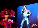 chris macdonald performing viva las vegas in black leather during the 60's portion of his tribute, memories of elvis in concert with his orchestra, back up singers and dancers.