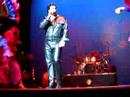 chris macdonald performing viva las vegas in black leather during the 60's portion of his tribute, memories of elvis in concert with his orchestra, back up singers and dancers.