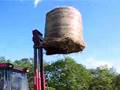 Tractor mounted forklift lifting a round bale