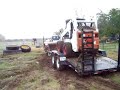 F250 4x4 pulling bobcat on trailer  in damp field