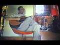 को Indian guitar in an orange chair भारत