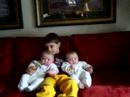 Elizabeth films and instructs Andrew holding the twins