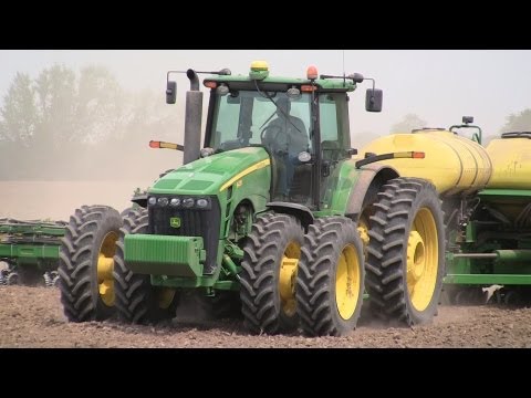 illinois - A 24 row John Deere planter pulled by a John Deere tractor puts down seed corn in a triangular-shaped field in DeKalb County, Illinois. The field was being p...