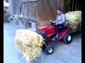 Rasentraktor transportiert Strohballen