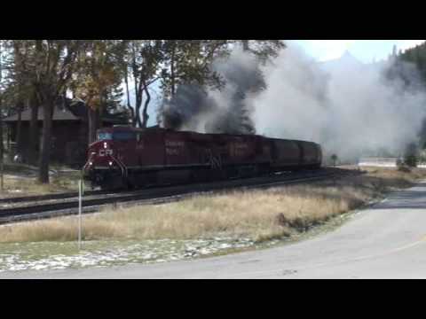 ES44AC - On a very windy day, a train of grain hoppers smokes its way into Field. Led by ES44AC 8707 it smokes its way towards the spiral tunnels. See my other video'...