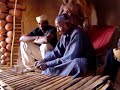 ibrahima diabat�, vieux balafoniste, jouant un de ses balafons dans la case commune de sa cour � djigu�ra (k�n�dougou - burkina-faso).