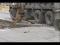 tearing up the sidewalk with a loader and putting in dumptruck.