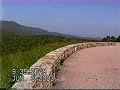recorded on june 6, 2003. shenandoah national park encompasses part of the blue ridge mountains in the state of virginia. this national park is long and narrow, with the broad shenandoah river and valley on the west side, and the rolling hills of the virginia piedmont on the east. the park is best known for skyline drive, a 105 mile road that runs the entire length of the park along the ridge of the mountains. the drive is particularly popular in the fall when the leaves are changing colors. during my visit to the park i visit many of the scenic overlooks. i also take a hike to dark hollow falls. the video ends with some deer in the park.