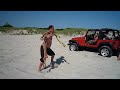 Jeep Rubicon pulls out stuck Explorer on beach.
