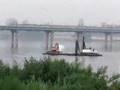 An Excavator Paddling a Barge in Russia