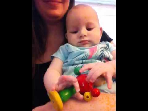 Lia spielt mit einer Holzrassel