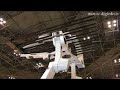 安川電機の液晶ガラス基板搬送用ロボット「MOTOMAN-CDL3000D」は東京ビッグサイトで行われた２００８年度　ファインテックジャパンにて、アドバンスト ディスプレイ オブ ザ イヤーの製造装置部門でグランプリを受賞しました。ロボットの上下昇降軸は安川電機独自のダブルリンク式支柱機構を採用し、ダブルアームで可搬質量100kg／アーム、上下昇降ストローク4000mm、前後伸縮ストローク5200mmの実現によって、第10世代対応超大形液晶ガラス基板2850×3050mmサイズの搬送を可能にしました。ダブルリンク式支柱機構による高剛性とフレキシブルな動作でアームのたわみが少なく、また、液晶ガラス基板を搭載するハンドのねじれ方向補正は、左右のリンク式支柱による上･下動のひねり動作でレベルの調整が可能になりました。これらの高剛性機構と高い自由度のほか、駆動モータや減速機を含めた全体の軽量化、動力伝達系の改善によって、搬送速度はクラス最速を実現し、タクトタイムは37.4秒の高速搬送を可能にしました。安川電機では今後も、小形液晶ガラス基板から第10世代の超大形液晶ガラス基板まで、それぞれの特長を活かした液晶ガラス基板搬送ロボットを市場に供給し、FPDロボット事業を更に強化していく方針です。