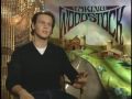 move back upstate to the El Monaco in order to help save the motel from being taken over by the bank. Upon hearing that a planned music and arts festival has lost its permit from the neighboring town of Wallkill, NY, Elliot calls producer Michael Lang (Jonathan Groff) at Woodstock Ventures to offer his familys motel to the promoters and generate some much-needed business. Elliot also introduces Lang to his neighbor Max Yasgur (Eugene Levy), who operates a 600-acre dairy farm down the road. ...