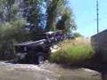 F-650 4x4 Six door pickup driving next to the road.