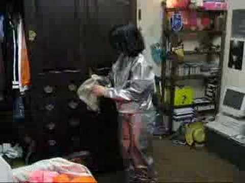 Rainweargirl - Slipping into a PVC overall and putting on a grey gasmasks.