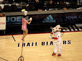 woman flips bowls on her head while riding a unicycle