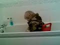 harrison hall riding his toy car in the bath full clothed
