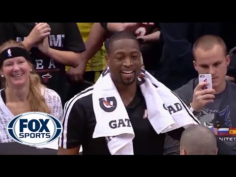 interview - After the win over Minnesota, Dwyane Wade does a little cleaning during LeBron's postgame interview.