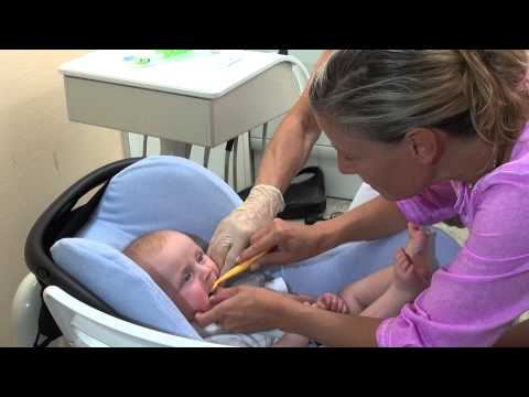 Eltern putzen Kinderzähne sauber - Erste Zähne putzen